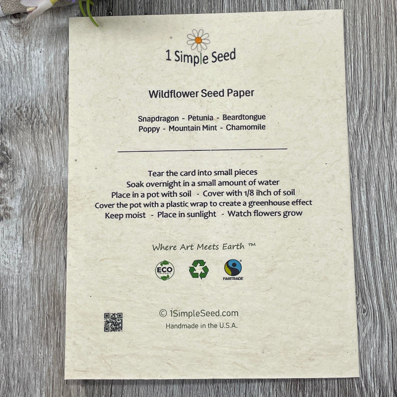 Wildflower seed paper card with planting instructions on a wooden surface