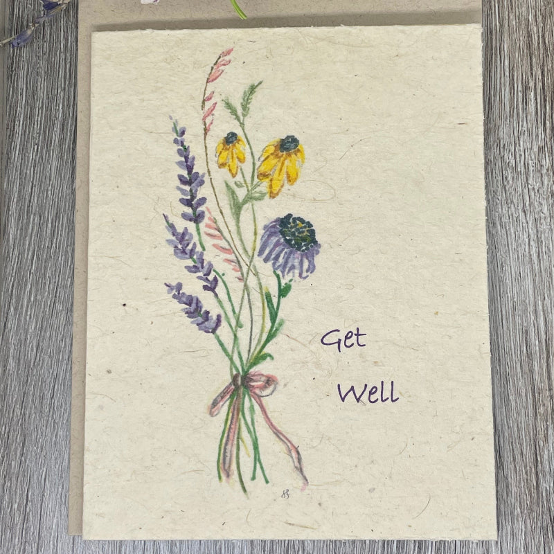 A folded plantable card with hand-drawn watercolor art of a bouquet and the text 'Get Well' on the front. plantable card. get well. wildflower seed paper.